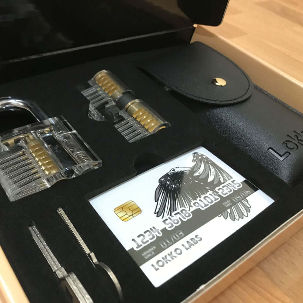Close up of Lokko lock pick set contents. 2 locks, 3 keys, wallet with lock picks and spy kit with lockpicks and tools