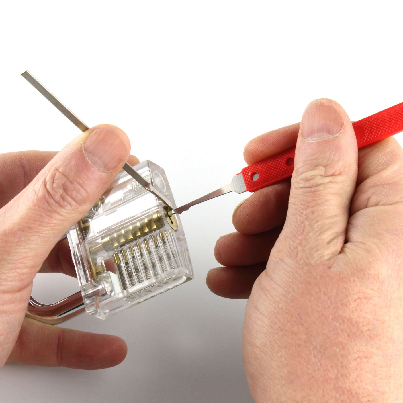 Person using a lock picking kit on a clear practice lock to demonstrate lock picking skills.
