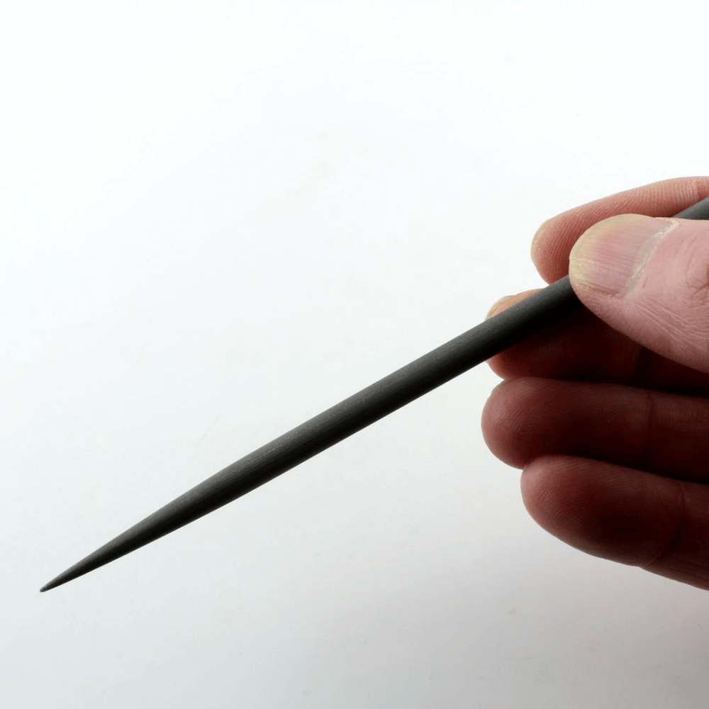 Hand holding an impressioning file on a white background