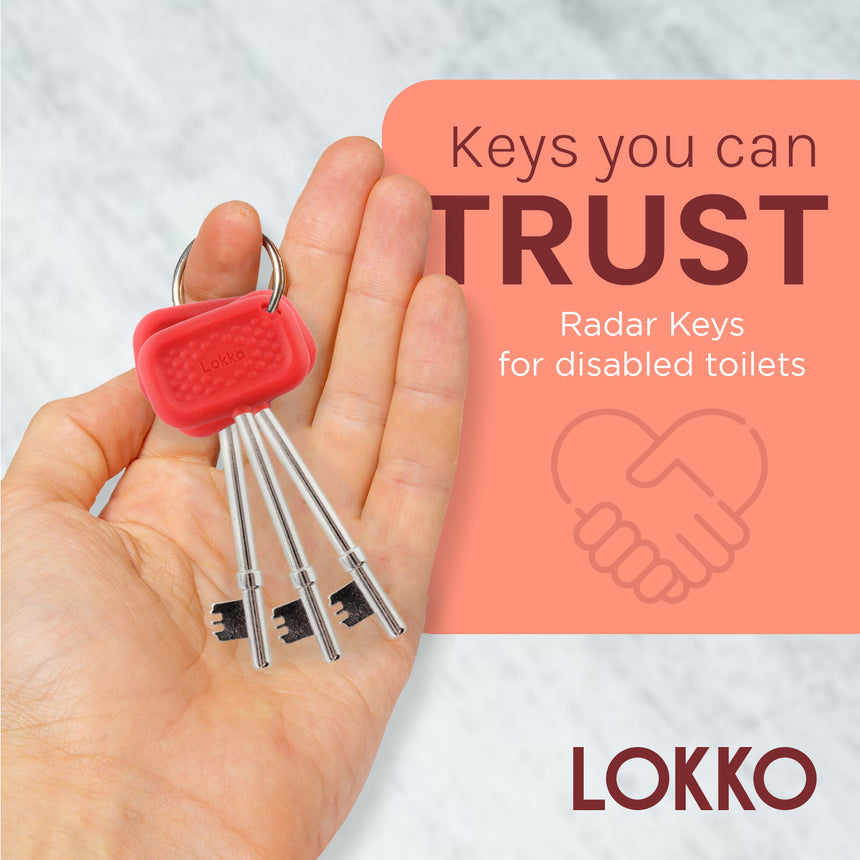 "Hand holding Lokko red radar keys set for disabled toilets, emphasizing trust and comfort with rubber grip handles."